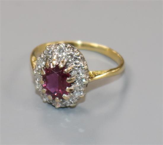 An 18ct gold, ruby and diamond oval cluster ring, size L.